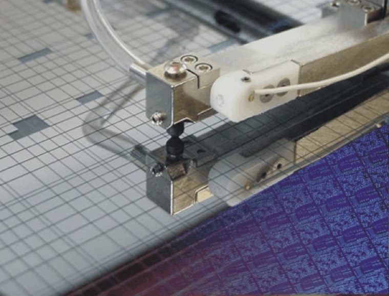 A pick and place head positioned over a die grid